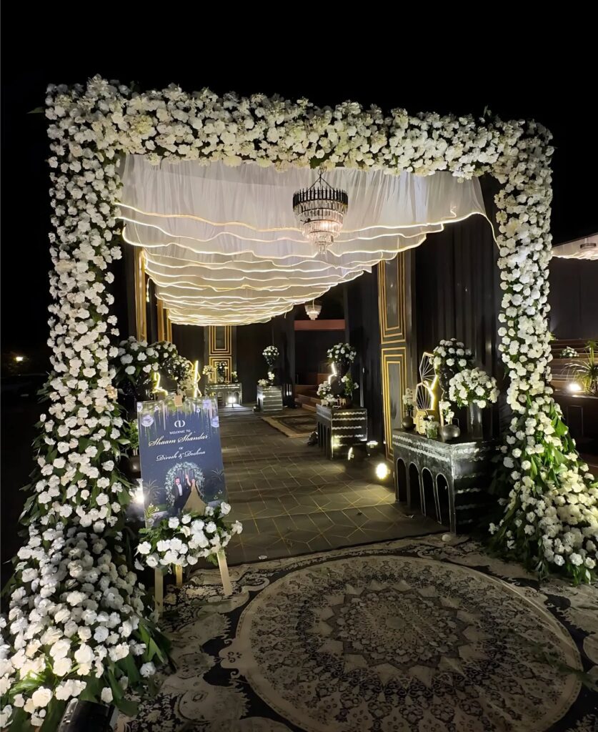 White floral wedding entrance illuminated at night
