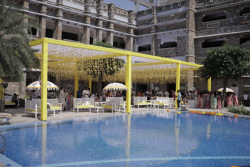 Yellow poolside pavilion for a Haldi celebration