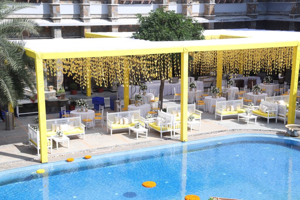 Yellow poolside Haldi pavilion with floral decor