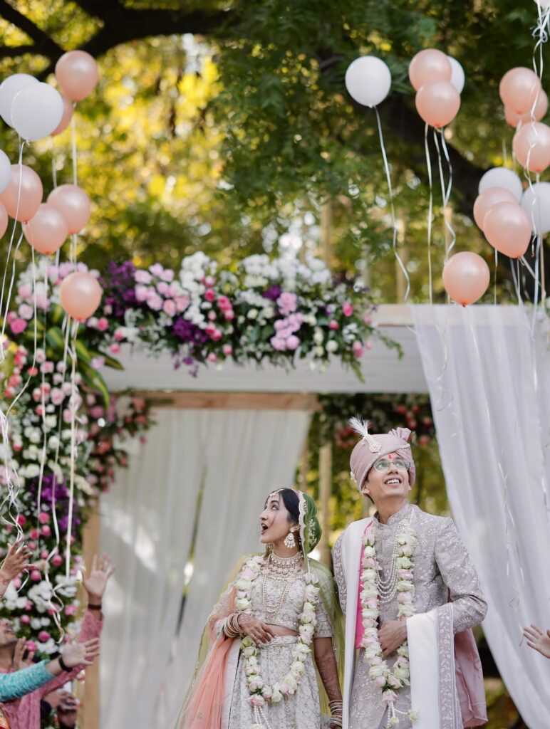 Couple beneath a floral celebration entrance